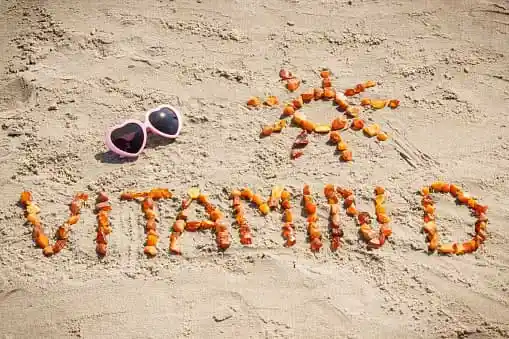 Vitamin D written on sand with sunglasses